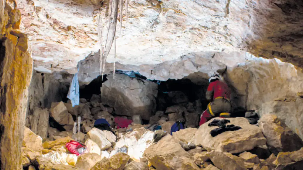Person erkundet große Höhle mit Ausrüstung.