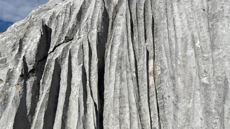 Detailaufnahme eines gefalteten Felsens mit Rissen.