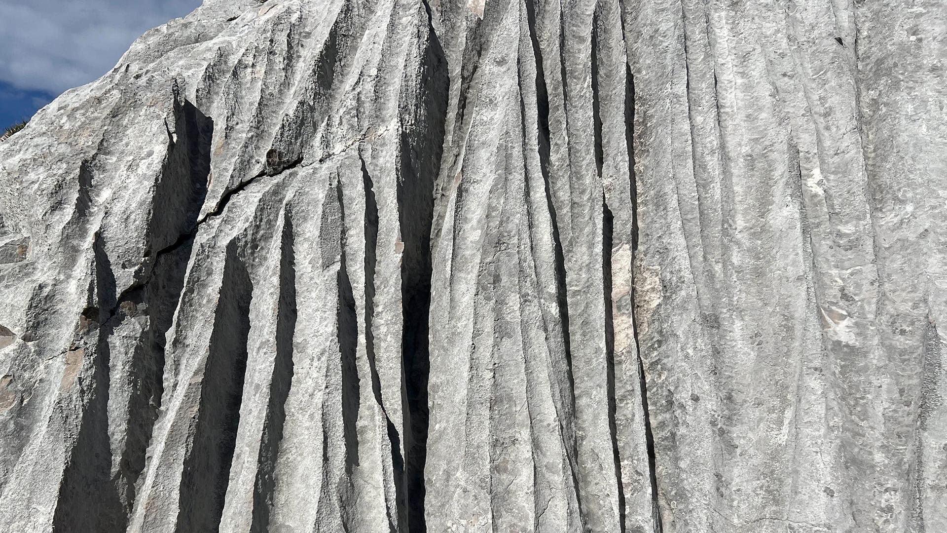 Detailaufnahme eines gefalteten Felsens mit Rissen.