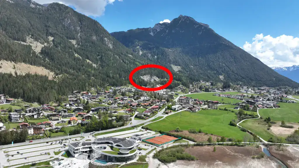 Bergdorf mit umliegenden Wäldern und markierter Stelle